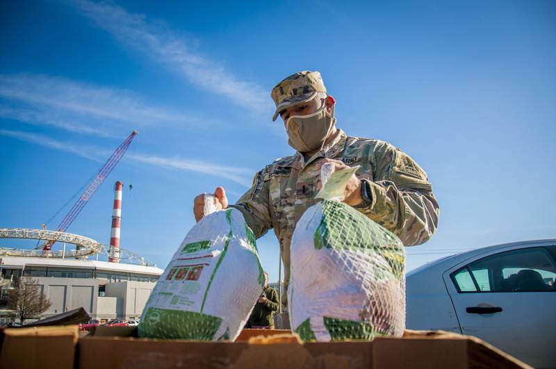 U.S. Army 1st Lt. Edwin Escobar, assigned to the Connecticut National Guard's 643rd Military Police Company, grabs a couple of turkeys for families during the Bridgeport Rescue Mission's annual Great Thanksgiving Project on Nov. 20, 2020, in Bridgeport, Conn