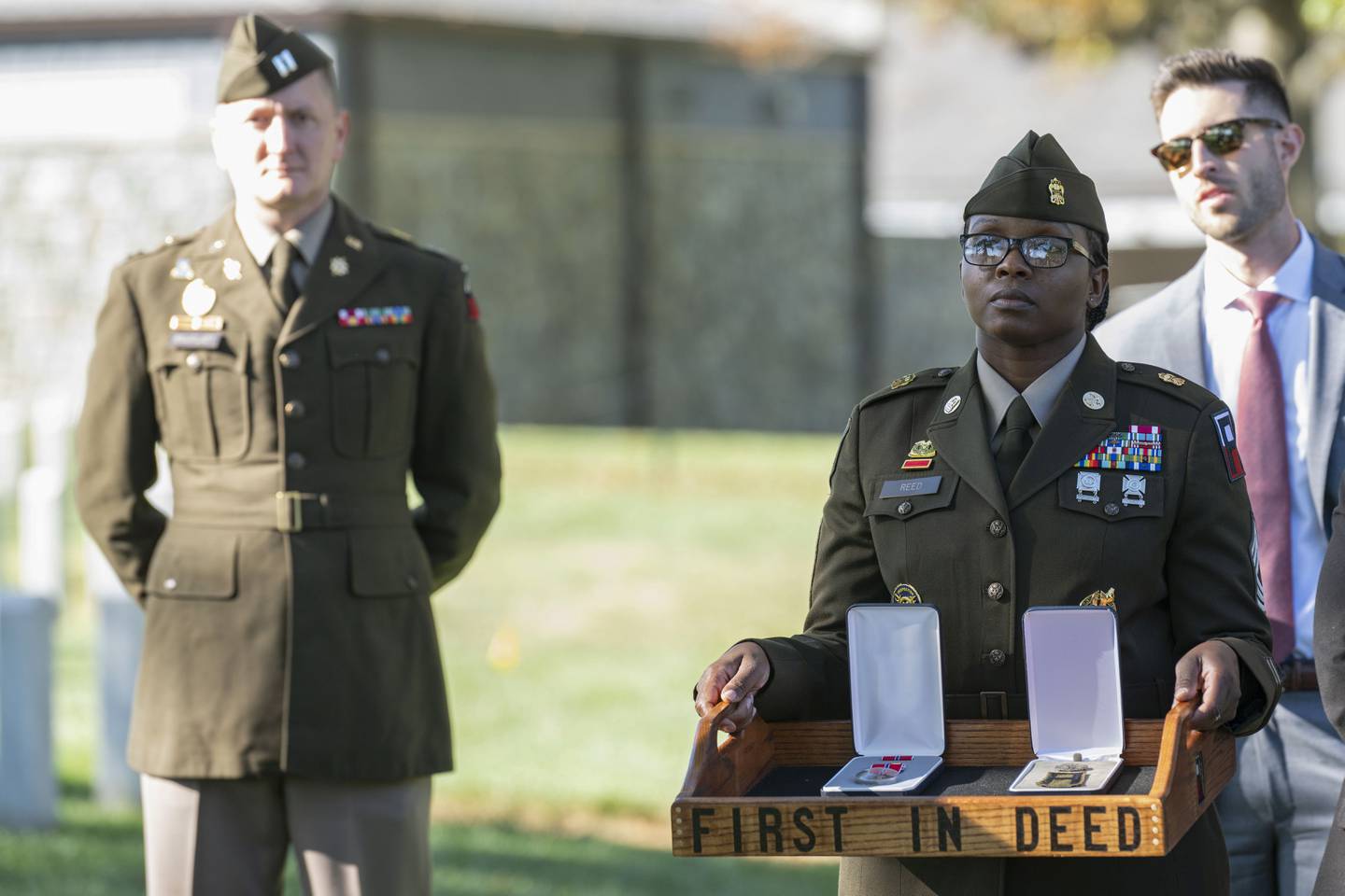 A soldier, right, holds the Bronze Star and Combat Medic Badge to be posthumously presented to Cpl. Waverly B. Woodson Jr. during a ceremony at Arlington National Cemetery on Tuesday, Oct. 11, 2023 in Arlington, Va.