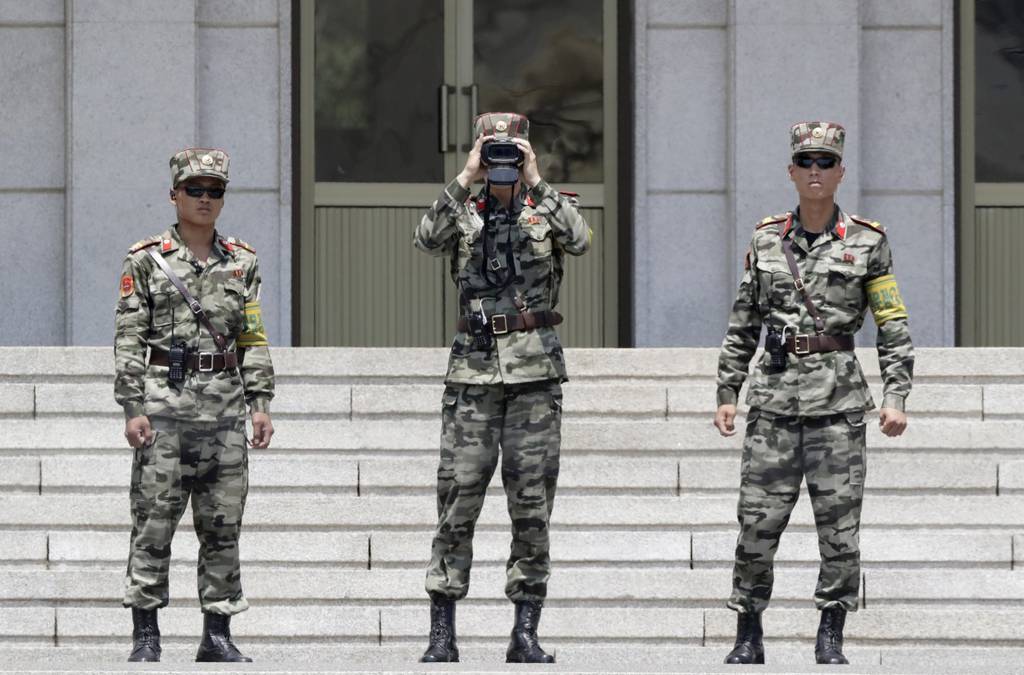 North Korean soldiers look at the South side, seen during a press tour at the Panmunjom in the Demilitarized Zone, South Korea.