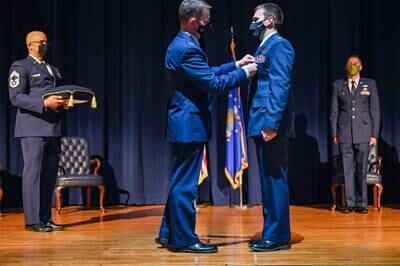 Col. John Schutte, 19th Airlift Wing commander, presents the Distinguished Flying Cross to Maj. Christopher Richardson, 61st Airlift Squadron pilot, at Little Rock Air Force Base, Ark., May 10, 2021. (Senior Airman Aaron Irvin/Air Force photo)
