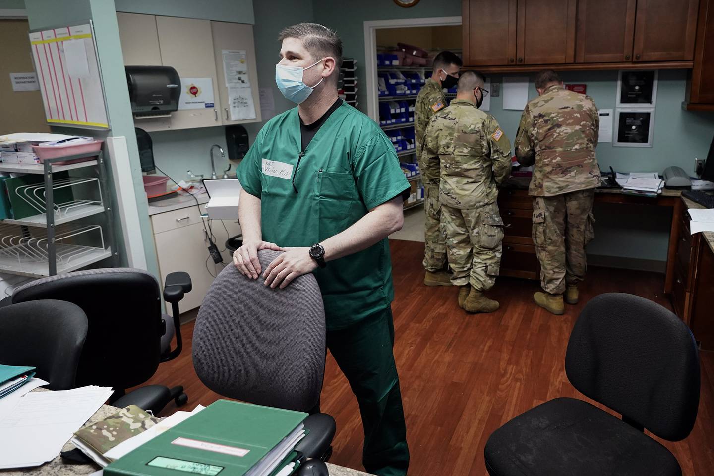 Registered nurse Army Maj. Andrew Wieher, with the Urban Augmentation Medical Task Force, stands at a nurses station inside a wing at United Memorial Medical Center, Thursday, July 16, 2020, in Houston.