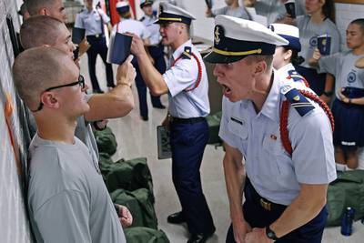 In this July 1, 2019, file photo, Whisky 2 company Cadre Jacob Denns, right, shouts instructions to swab Nicolas Fisher, left, of Pelham, N.H., on the first day of a seven-week indoctrination to military academy life for the Class of 2023 at the U.S. Coast Guard Academy in New London, Conn.