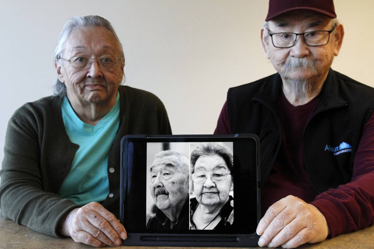 Pauline Golodoff, left, and George Kudrin hold an iPad featuring images of their deceased spouses, Gregory Golodoff and Elizabeth Golodoff Kurdrin, Friday, Dec. 1, 2023, in Anchorage, Alaska.