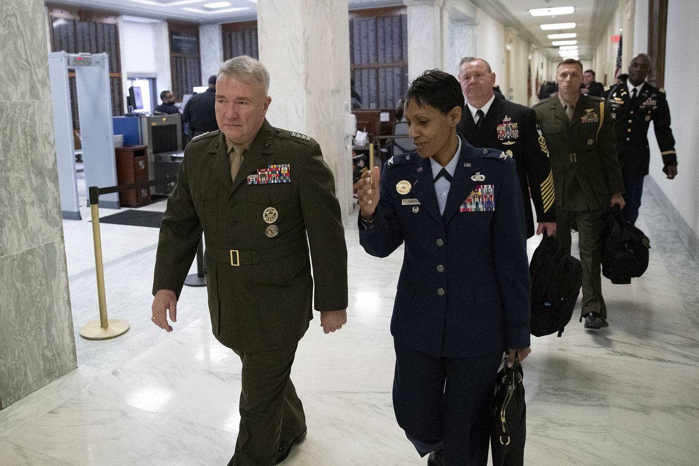 U.S. Marine Corps Gen. Kenneth McKenzie Jr., commander of U.S. Central Command, left, walks to a House Armed Services hearing on Capitol Hill on March 10, 2020, in Washington.