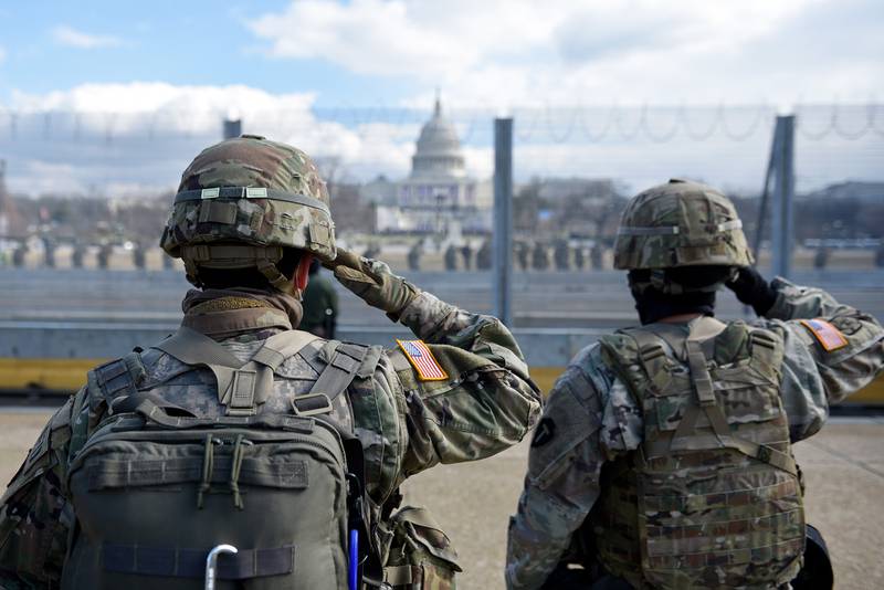 Members of the National Guard salute as they stand near the U.S. Capitol while the national anthem is sung during the inauguration of President-elect Joe Biden and Vice President-elect Kamala Harris on Jan. 20, 2021, in Washington.