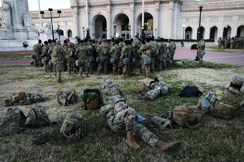 Members of the National Guard wait to depart Union Station as the city remains under tight security during the presidential inauguration on Jan. 20, 2021, in Washington.