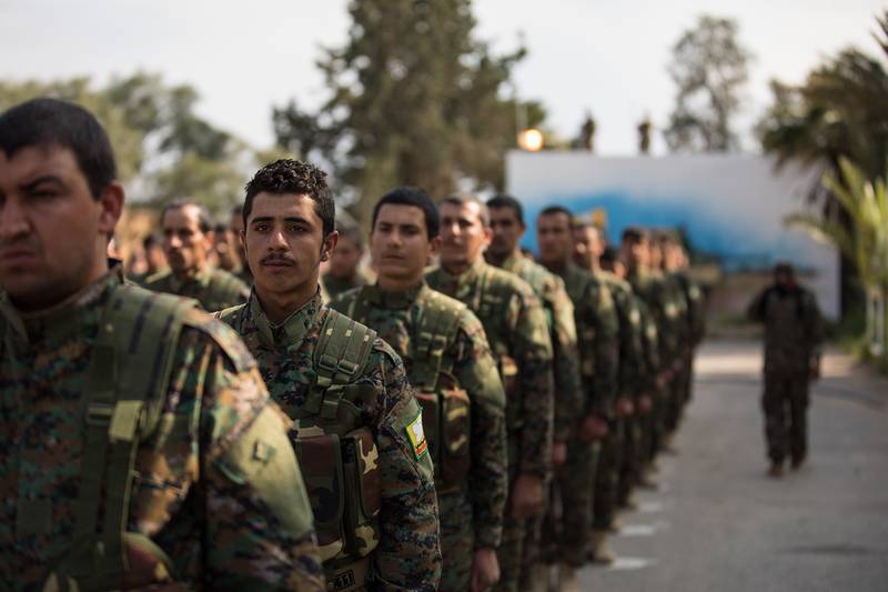 Members of the Syrian Democratic Forces stand in formation