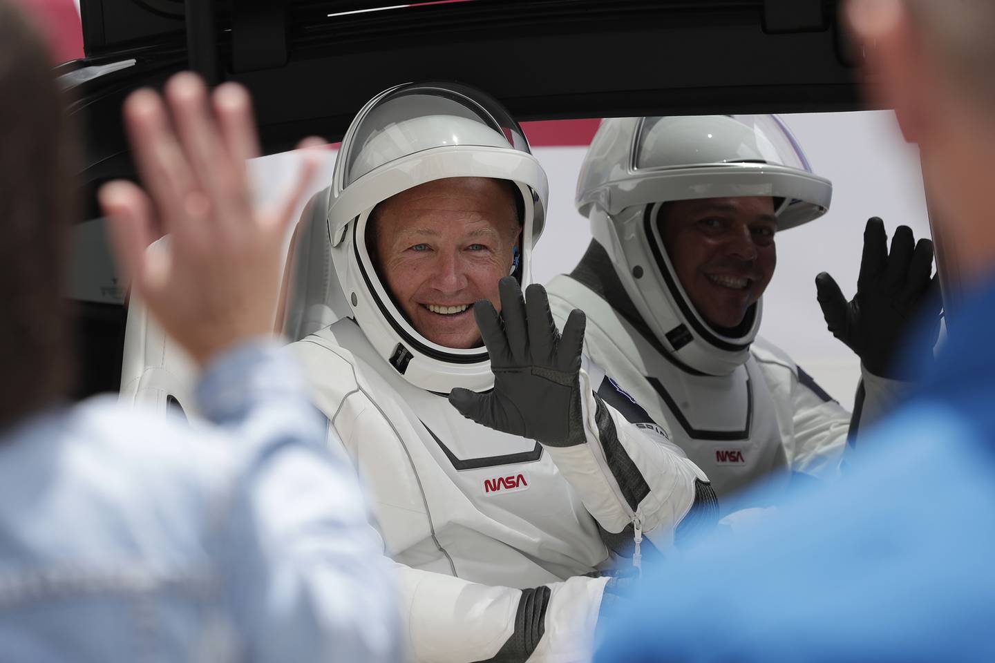 NASA astronauts Douglas Hurley, left, and Robert Behnken ride a Tesla SUV from the Neil A. Armstrong Operations and Checkout Building on their way to Pad 39-A, at the Kennedy Space Center in Cape Canaveral, Fla., Wednesday, May 27, 2020.