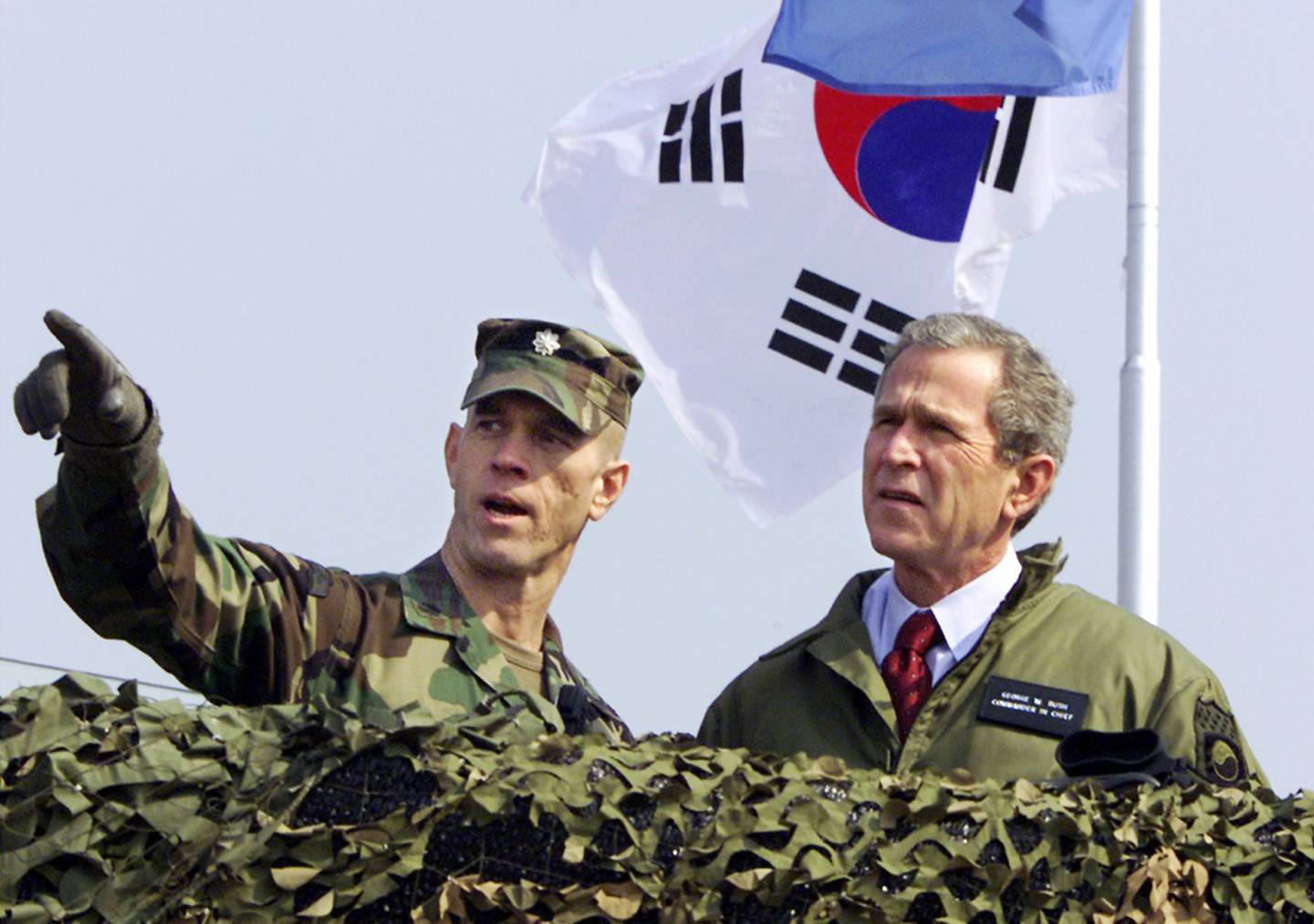 President George W. Bush, right, looks out at North Korea from Observation Point Ouellette in the Demilitarized Zone, the tense military border between the two Koreas, in Panmunjom, Korea, on Feb. 20, 2002.
