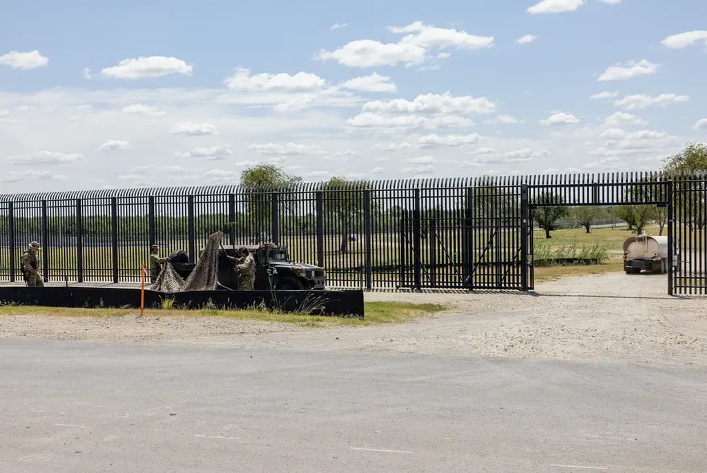 Members of the Texas National Guard set up a shade structure while they guard a gate along the border wall in Del Rio on September 16, 2021.