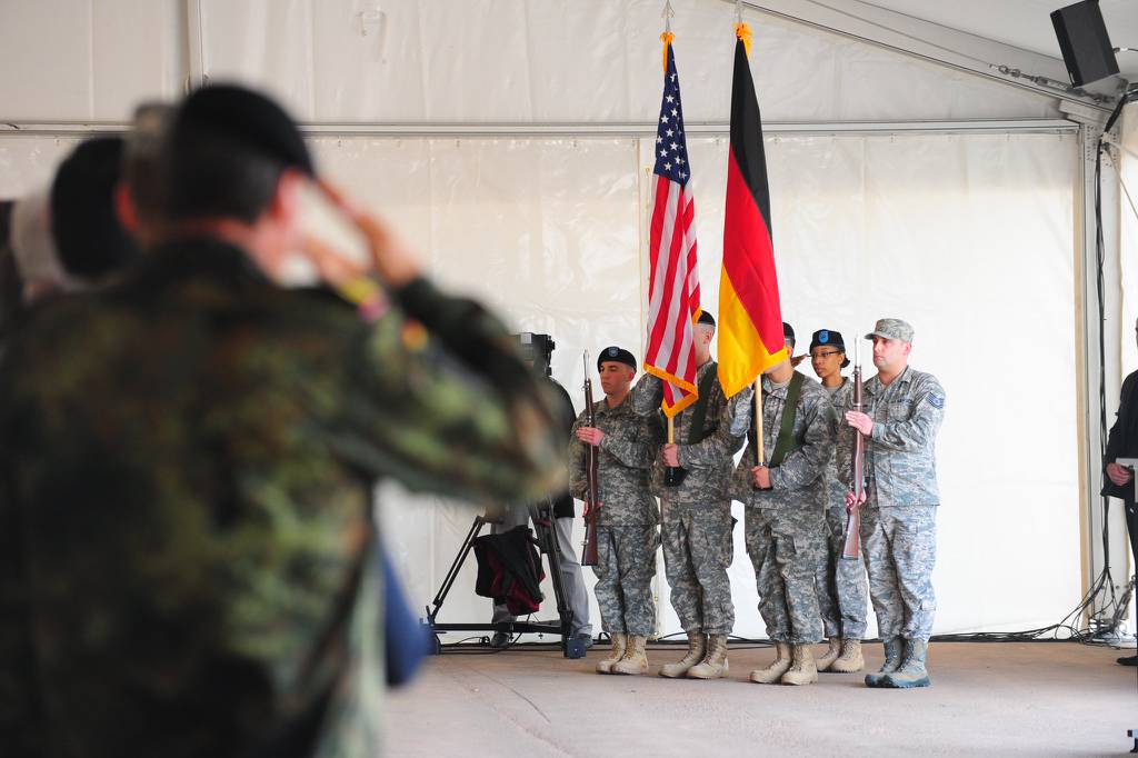 Attendees salute the U.S. and German flags during the groundbreaking ceremony here for the Rhine Ordnance Barracks Medical Center Replacement, Oct. 24, 2014, in Weilerbach, Germany.