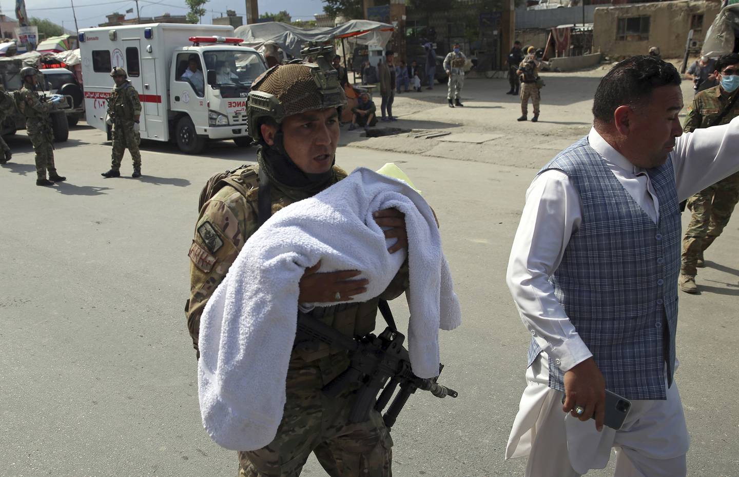 An Afghan security officer carries a baby after gunmen attacked a maternity hospital, in Kabul, Afghanistan, Tuesday, May 12, 2020.