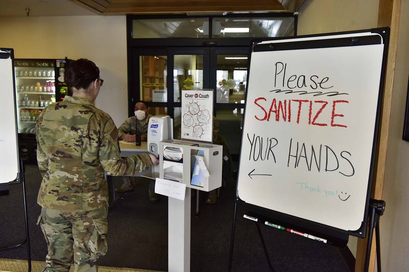 A 354th Medical Group Airman sanitizes her hands before entering the clinic