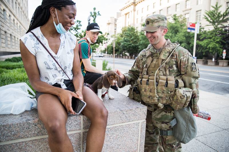 Capt. Michael LaPorta stops to talk to a D.C. resident, a recent medical school graduate and pediatric doctor, to play with her dog while visiting soldiers at traffic control points around the National Mall.