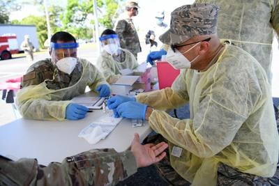 U.S. Air Force Lt. Col. Francisco Nieves, a physician with the 156th Medical Group, Puerto Rico Air National Guard, conducts a COVID-19 rapid test for Puerto Rico National Guard members at Muñiz Air National Guard Base, May 22, 2020.