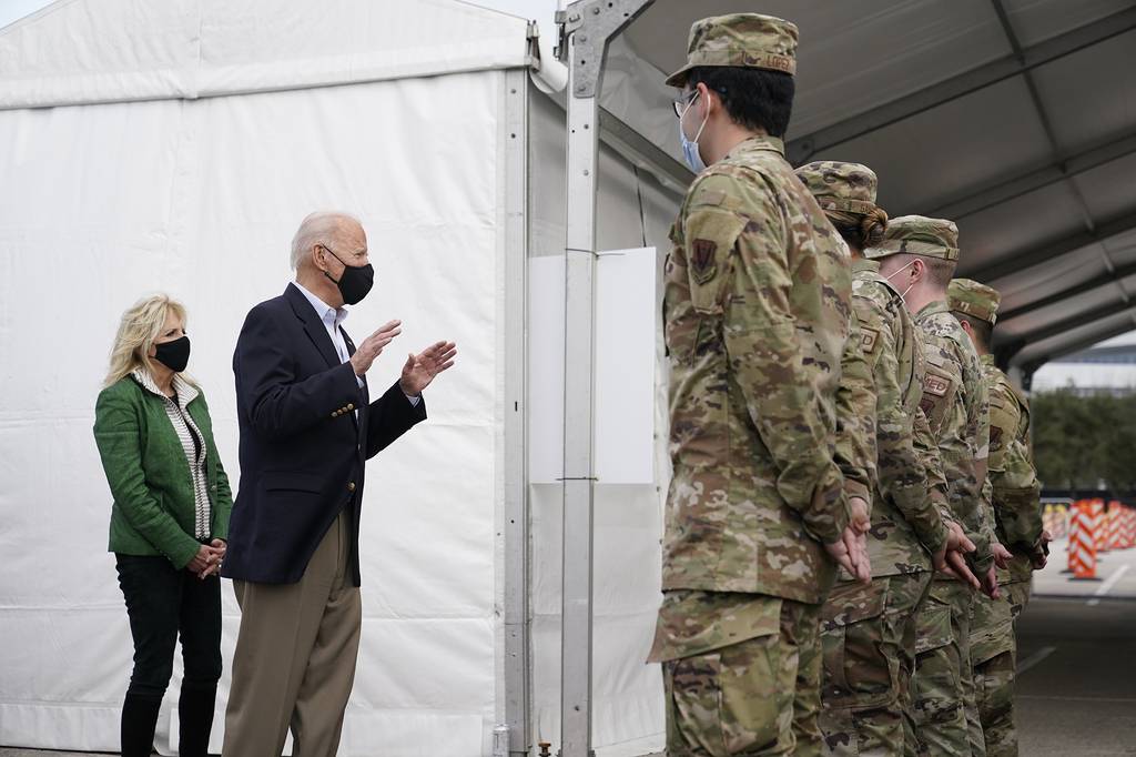 President Joe Biden and first lady Jill Biden meet with troops at a FEMA COVID-19 mass vaccination site at NRG Stadium, Friday, Feb. 26, 2021, in Houston.