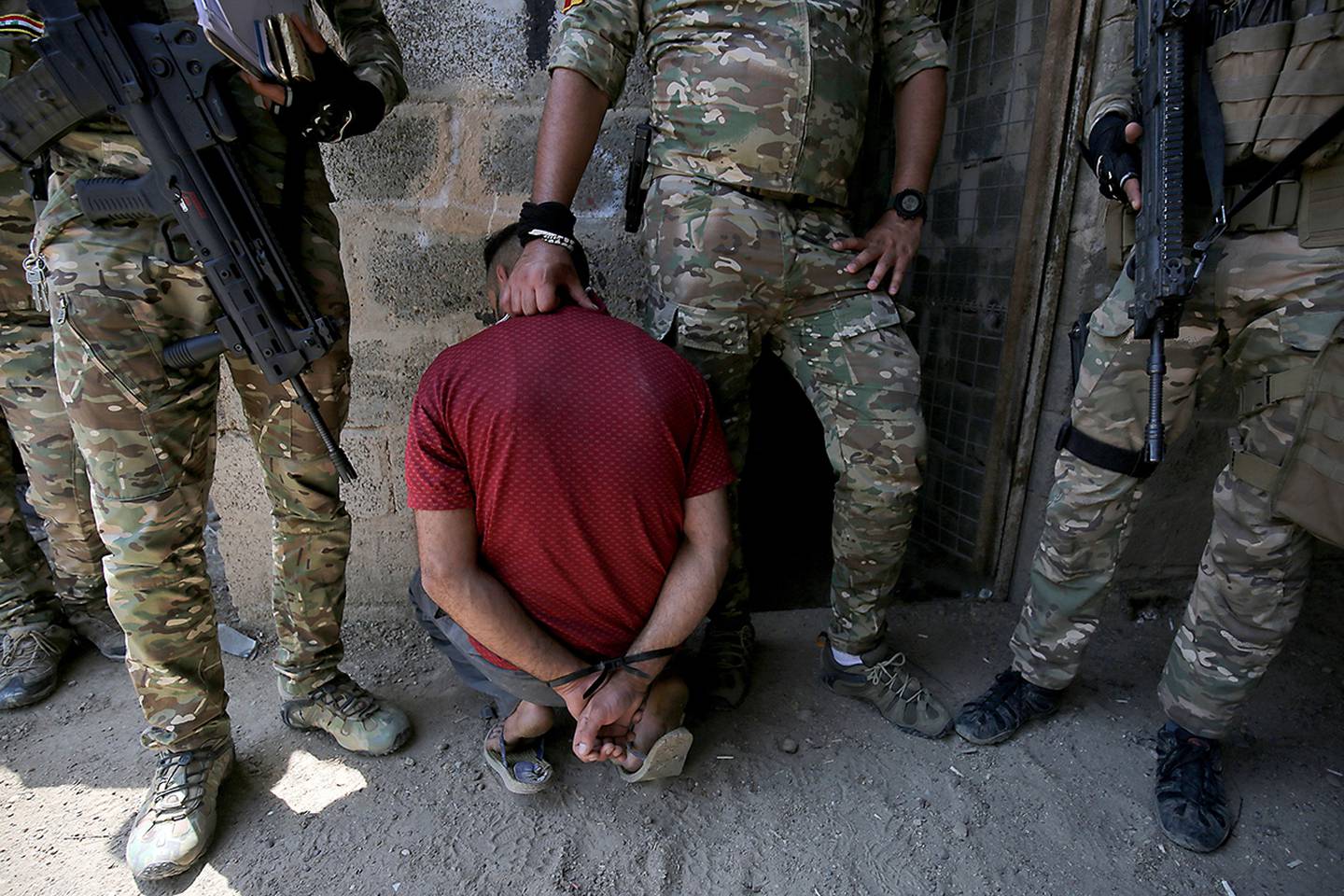 Iraqs rapid response forces detain a man as they storm a house in the Tarmiyah district, north of Baghdad, searching for wanted Islamic State group suspects on July 21, 2019.