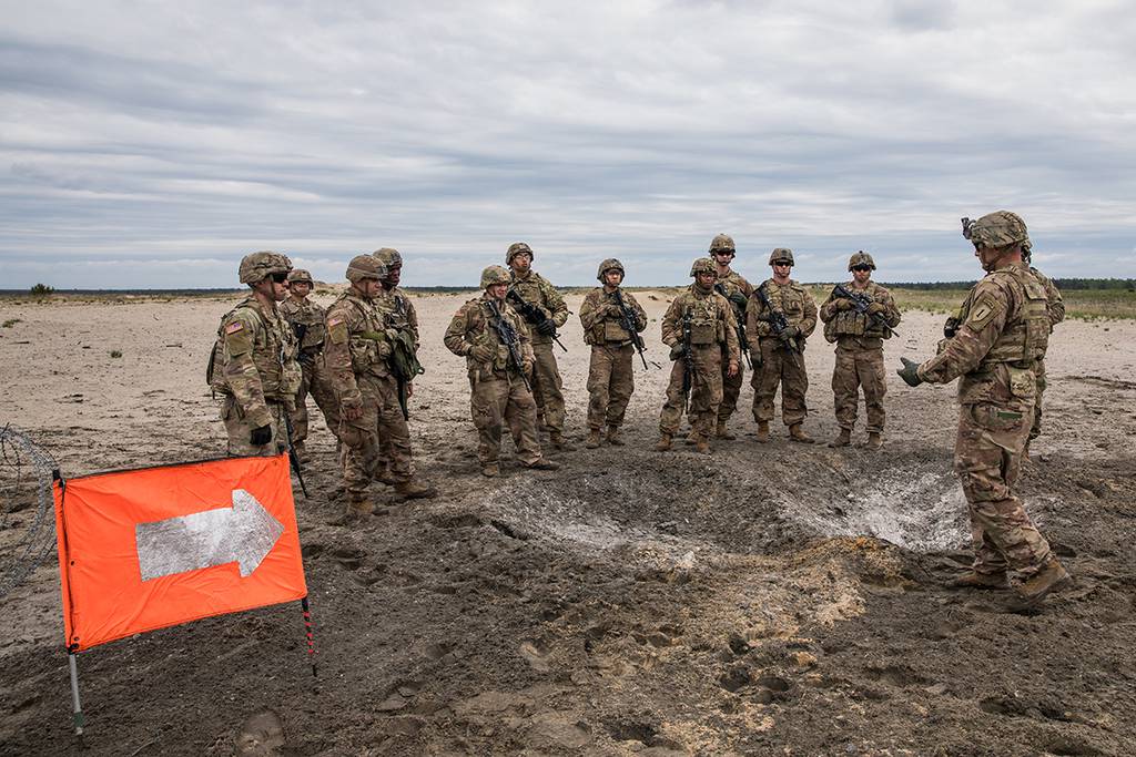 Soldiers conduct an after action review at the detonation site of a bangalore torpedo explosives during a day of breach training on a range near Camp Trzebień, Poland, May 23, 2019.