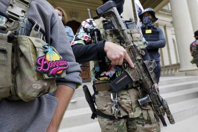 A group tied to the Boogaloo Bois holds a rally as they carry firearms at the Michigan State Capitol in Lansing, Mich., on Oct. 17, 2020.