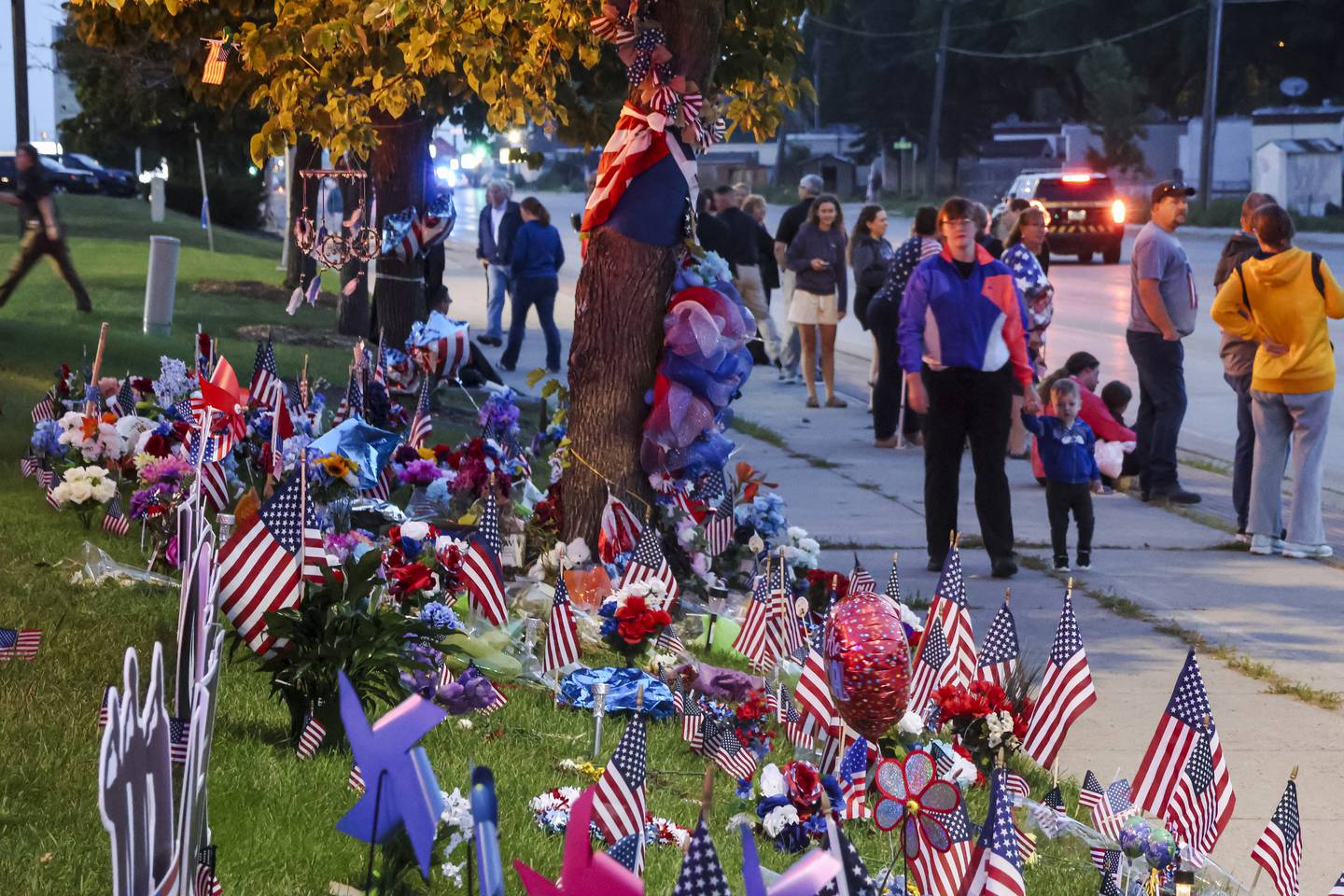 People gather during an escort of the late Fargo Police Officer Jake Wallin to his funeral near the intersection in Fargo, N.D., where he was fatally shot last week on Saturday, July 22. 2023.