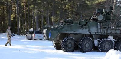 A soldier ground guides the M-SHORAD Stryker to start testing the route for practice for a training exercise the next day, March 9, 2022, near Rutja, Estonia.