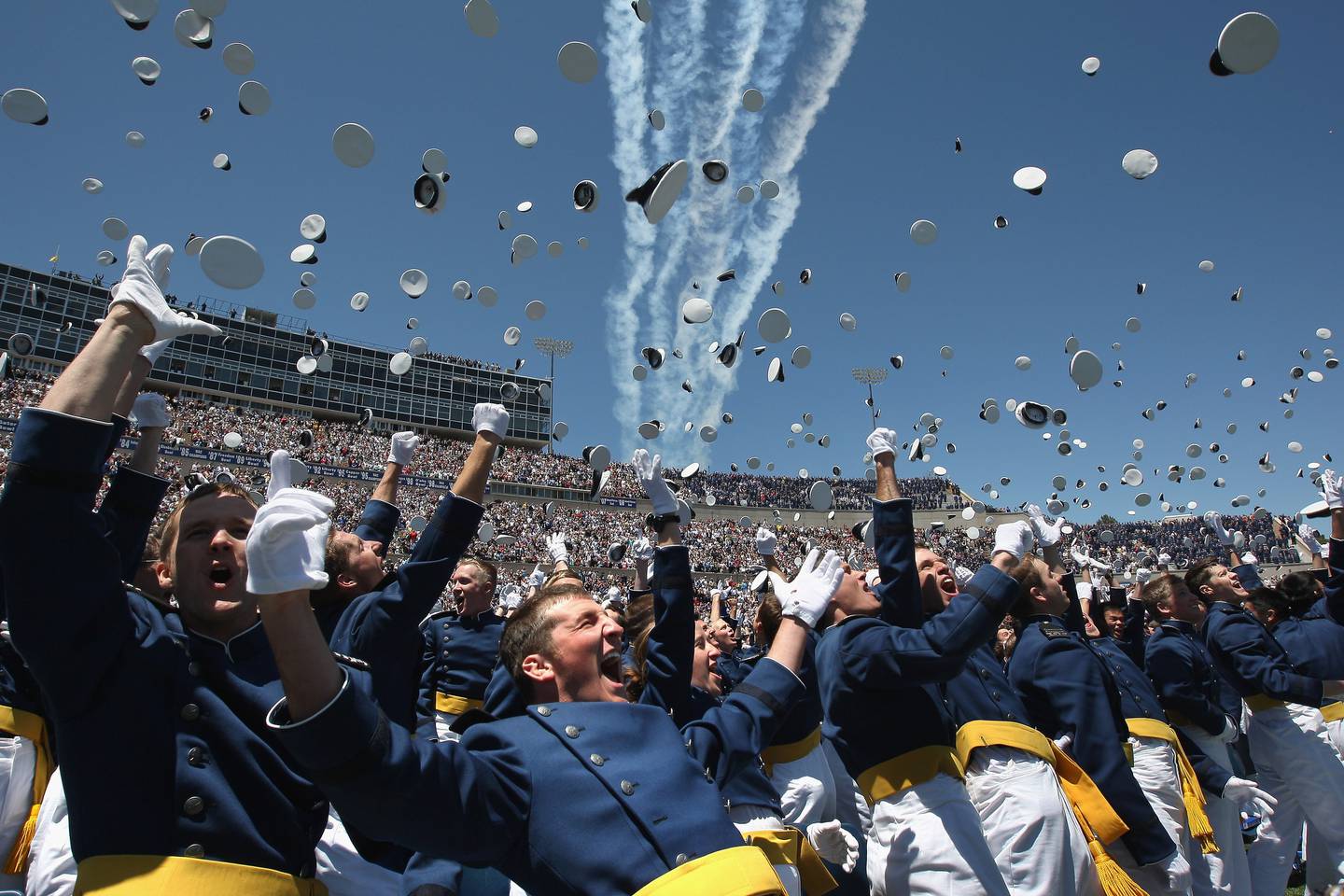 Air Force Academy graduates celebrate as a team of F-16 Thunderbirds flies over during the Air Force Academy graduation ceremony at Falcon Stadium on May 27, 2009 in Colorado Springs, Colorado. Vice President Joe Biden gave the commencement speech.