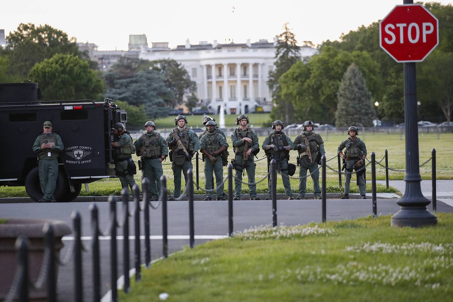 Law enforcement officers from Calvert County Maryland Sheriff's Office standing on the Ellipse, area just south of the White House in Washington, as they watch demonstrators protest the death of George Floyd, Sunday, May 31, 2020.