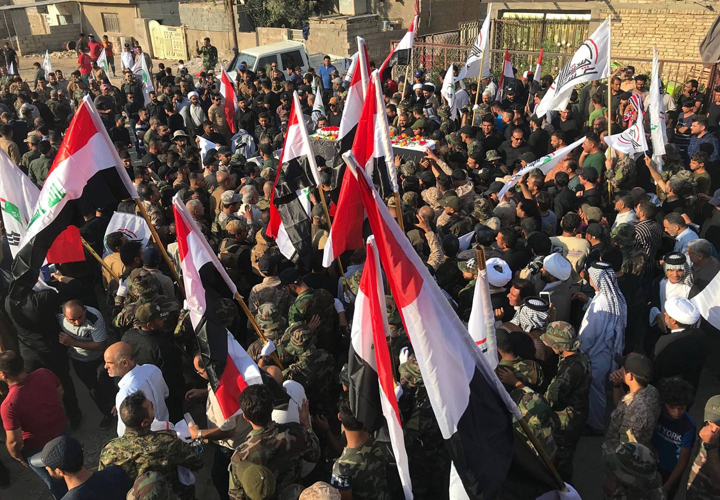 Mourners carry the coffin of Abu Ali al-Dabi, a fighter of the Popular Mobilization Forces killed in a drone attack, during his funeral procession in Baghdad, Iraq, Monday, Aug. 26, 2019.