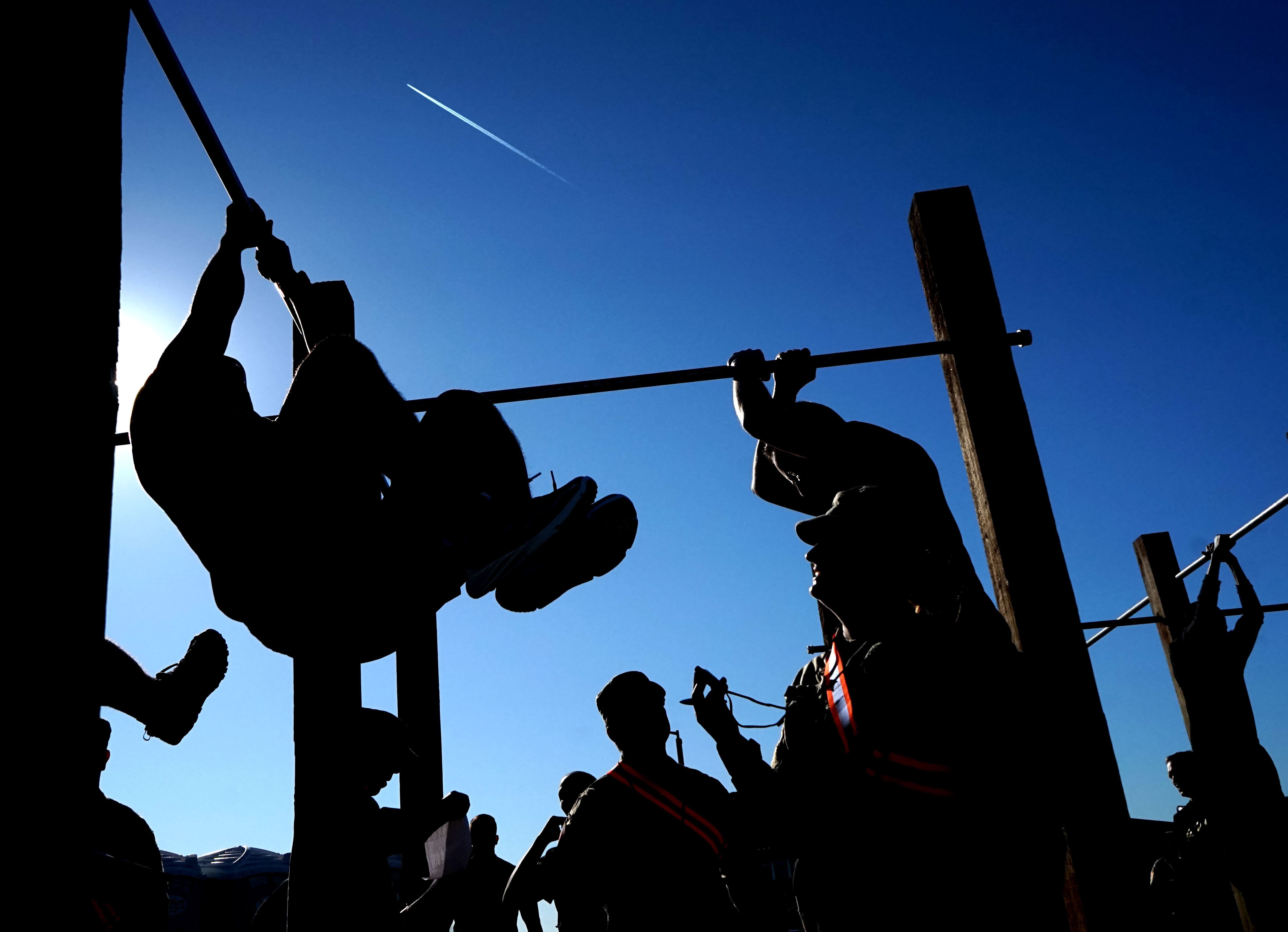 Soldiers from the 223rd Military Intelligence Battalion perform leg-tucks during an Army Combat Fitness Test at the Parks Reserve Forces Training Area in Dublin, California, March 16. (U.S. Army National Guard photo / Spc. Amy E. Carle)