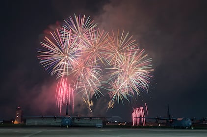Fireworks explode behind a C-130J Super Hercules during Celebrate America at Yokota Air Base, Japan, July 3, 2019.