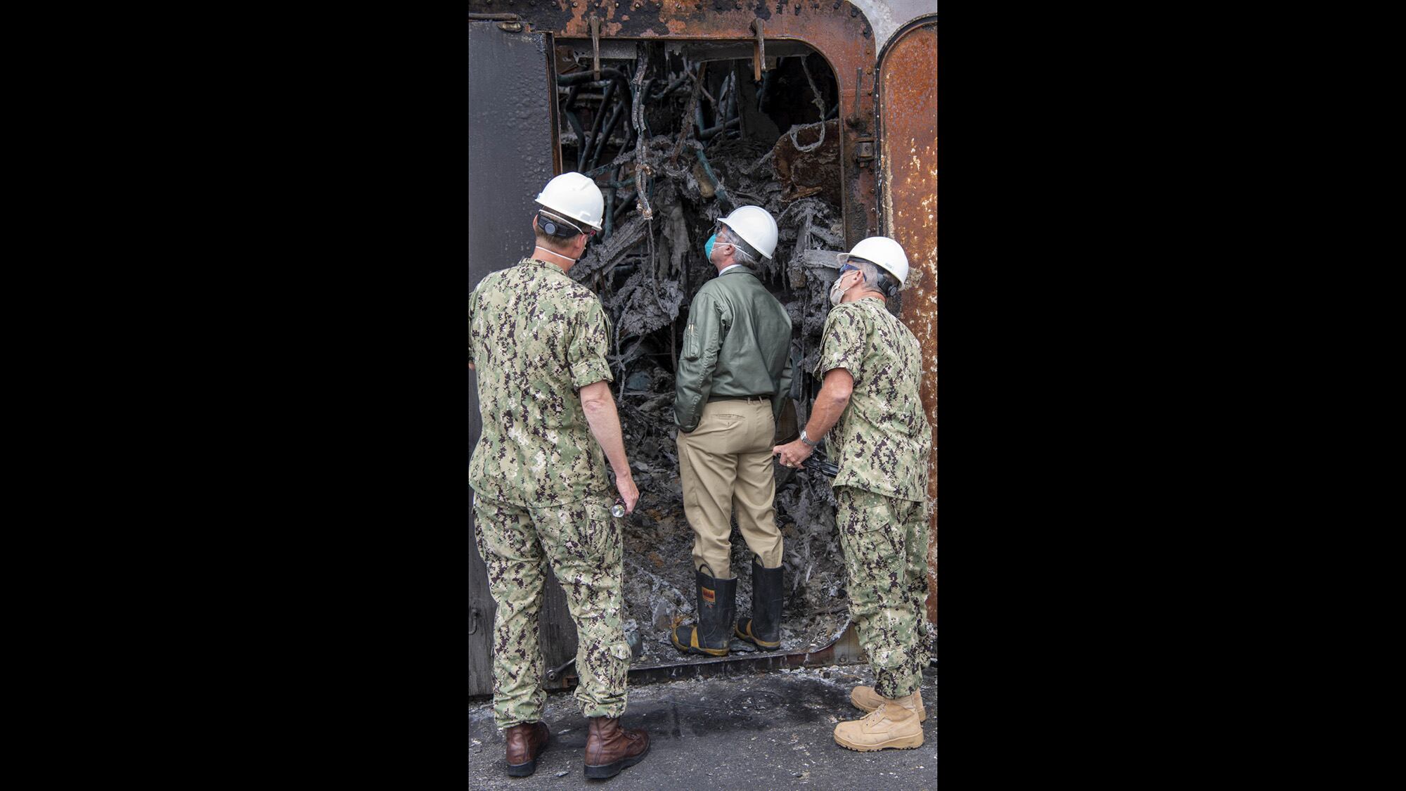 Secretary of the Navy Kenneth J. Braithwaite tours fire damage aboard the amphibious assault ship USS Bonhomme Richard (LHD 6) during a visit to the ship at Naval Base San Diego on July 27, 2020