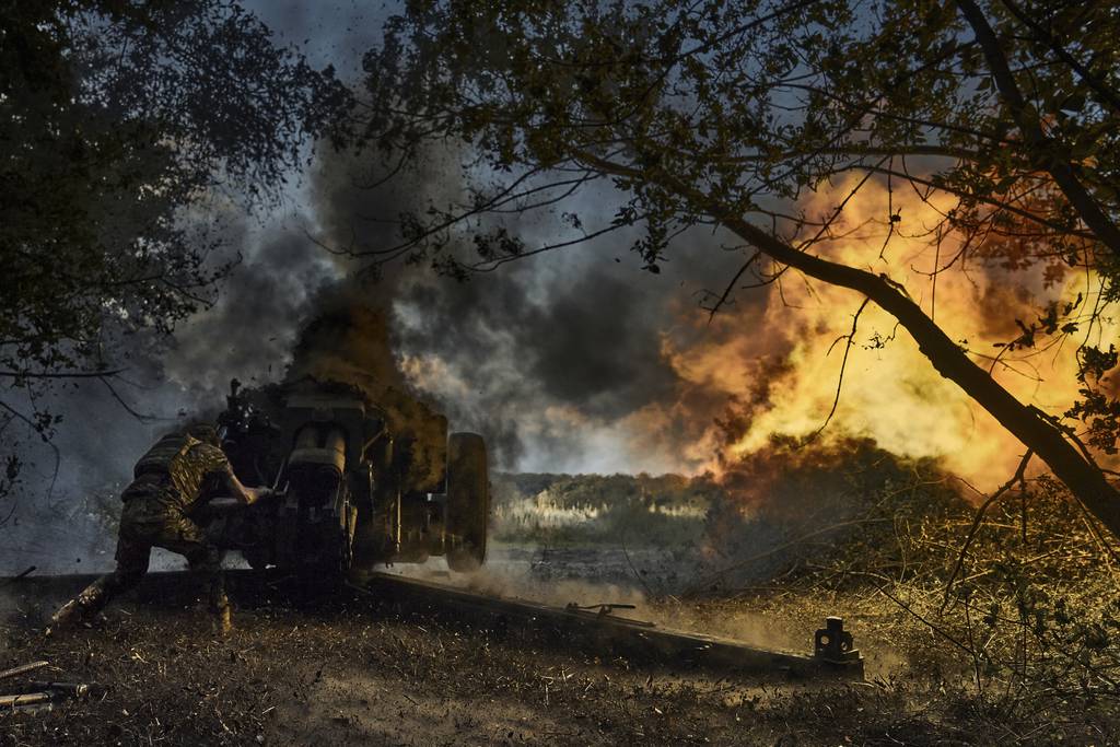 A Ukrainian policeman of special police unit fires a D-30 cannon towards Russian positions at the front line, near Kreminna, Luhansk region, Ukraine, Friday, July 7, 2023.