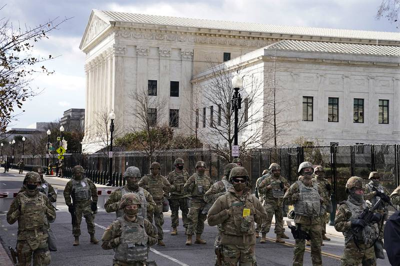 Members of the National Guard stand at a road block near the Supreme Court ahead of President-elect Joe Biden's inauguration ceremony, Wednesday, Jan. 20, 2021, in Washington.