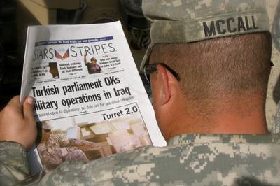 An Army MP reads an edition of the Stars and Stripes newspaper while in the Green Zone, Baghdad, Oct. 18, 2007.