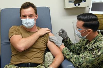 Hospital Corpsman 3rd Class David Tuil, assigned to the Preventive Medicine Department at Naval Health Clinic Hawaii, administers a Pfizer-BioNTech COVID-19 vaccine to Hospital Corpsman 3rd Class Gage Finn, Dec. 16, 2020.