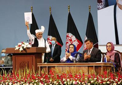 Afghan President Ashraf Ghani holds up a resolution on the last day of an Afghan Loya Jirga or traditional council, in Kabul, Afghanistan, Sunday, Aug. 9, 2020.