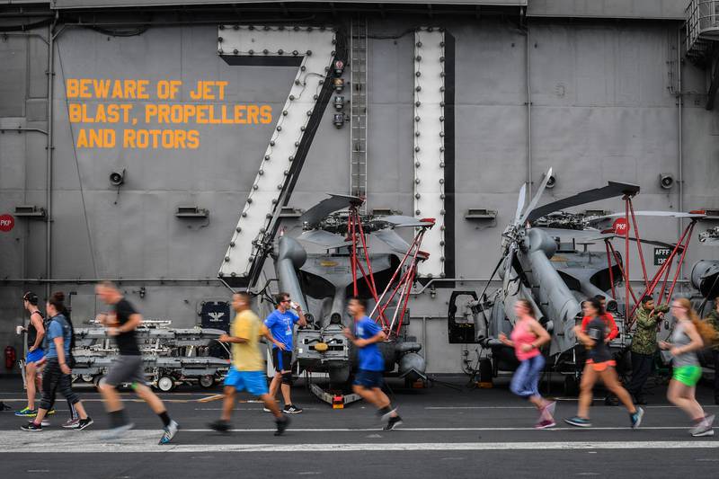 Sailors run during a Summer Sun 5K on the flight deck of the aircraft carrier USS Theodore Roosevelt (CVN 71) on July 21, 2019.