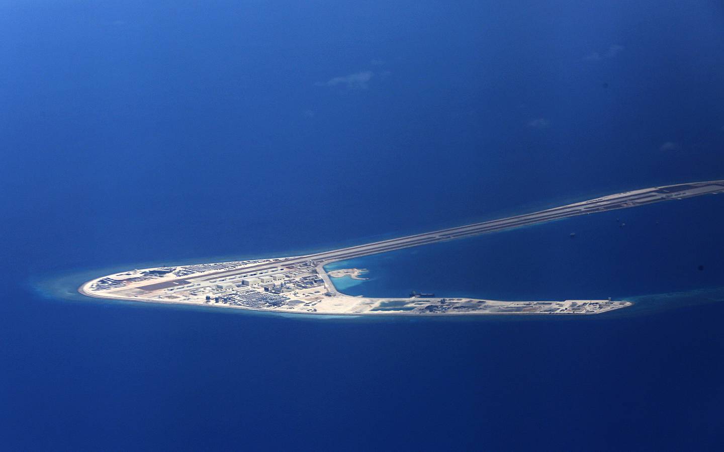 In this April 21, 2017, file photo, Chinese structures and an airstrip on the man-made Subi Reef at the Spratlys group of islands are seen from a Philippine Air Force C-130 transport plane off the disputed South China Sea in western Philippines.