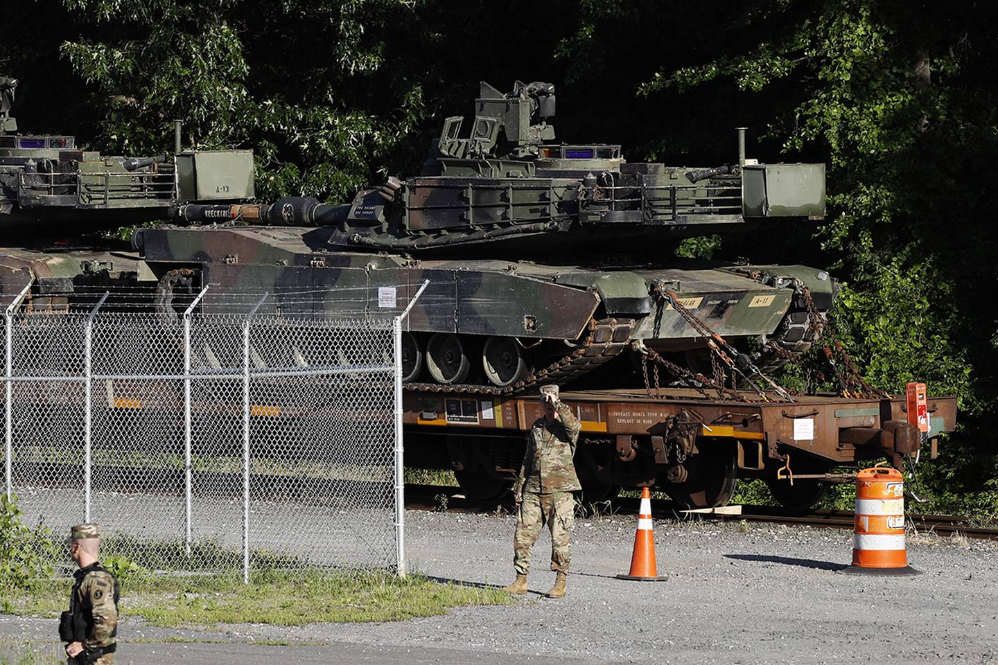 Military police walk near Abrams tanks on a flat car in a rail yard, Monday, July 1, 2019, in Washington, ahead of a Fourth of July celebration that President Donald Trump says will include military hardware.