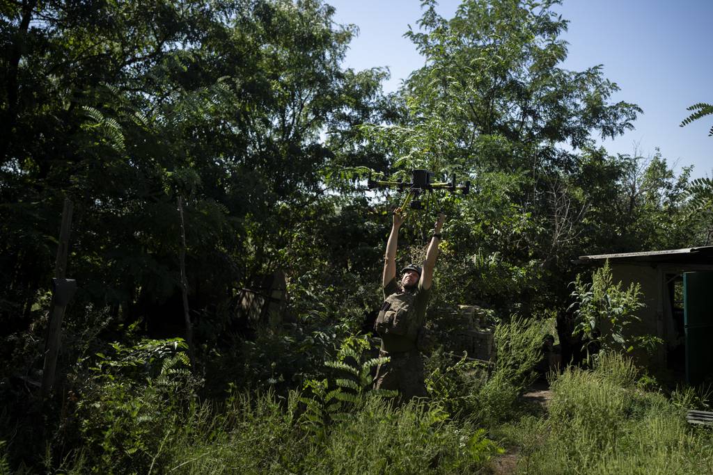 A Ukrainian solider grabs an intelligence drone during landing in the Luhansk region, Ukraine, Saturday, Aug. 19, 2023.