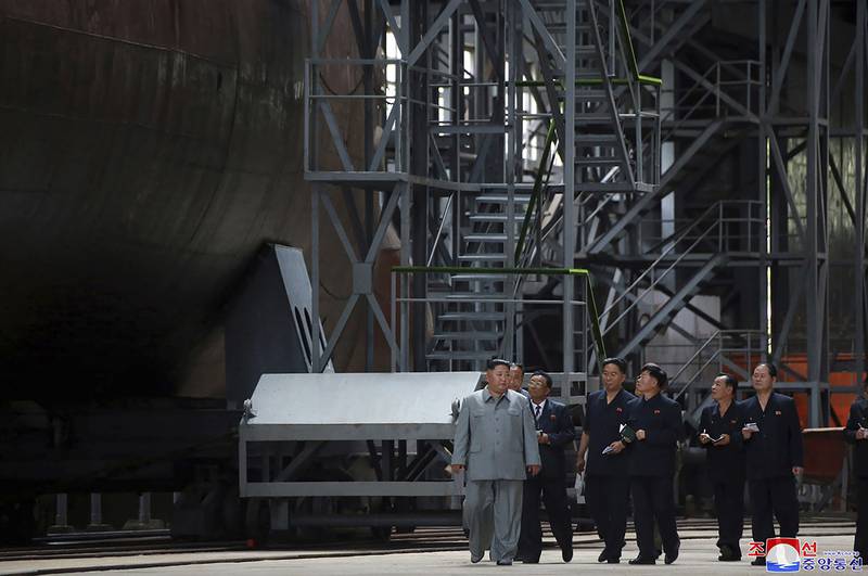 In this undated photo provided on Tuesday, July 23, 2019, North Korean leader Kim Jong Un, left, inspects a newly built submarine to be deployed soon, at an unknown location in North Korea.