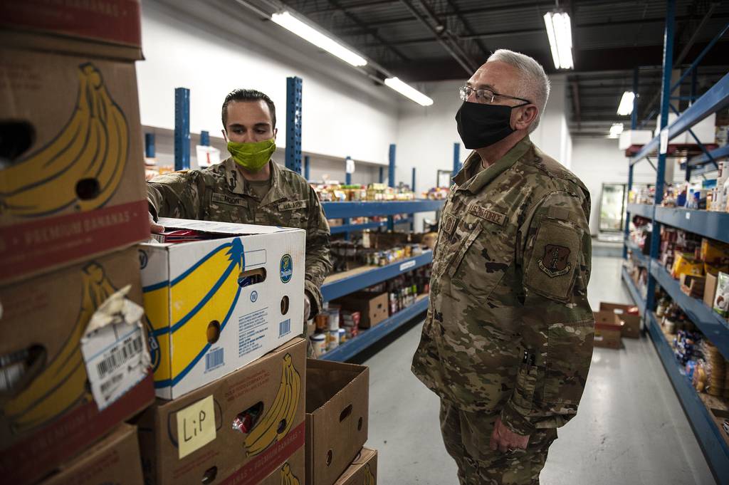 Command Chief Master Sgt. James Duty and Pfc. Brayden Moon explains foodbank operations at the Toledo Northwestern Ohio Food Banks, May 27, 2020.