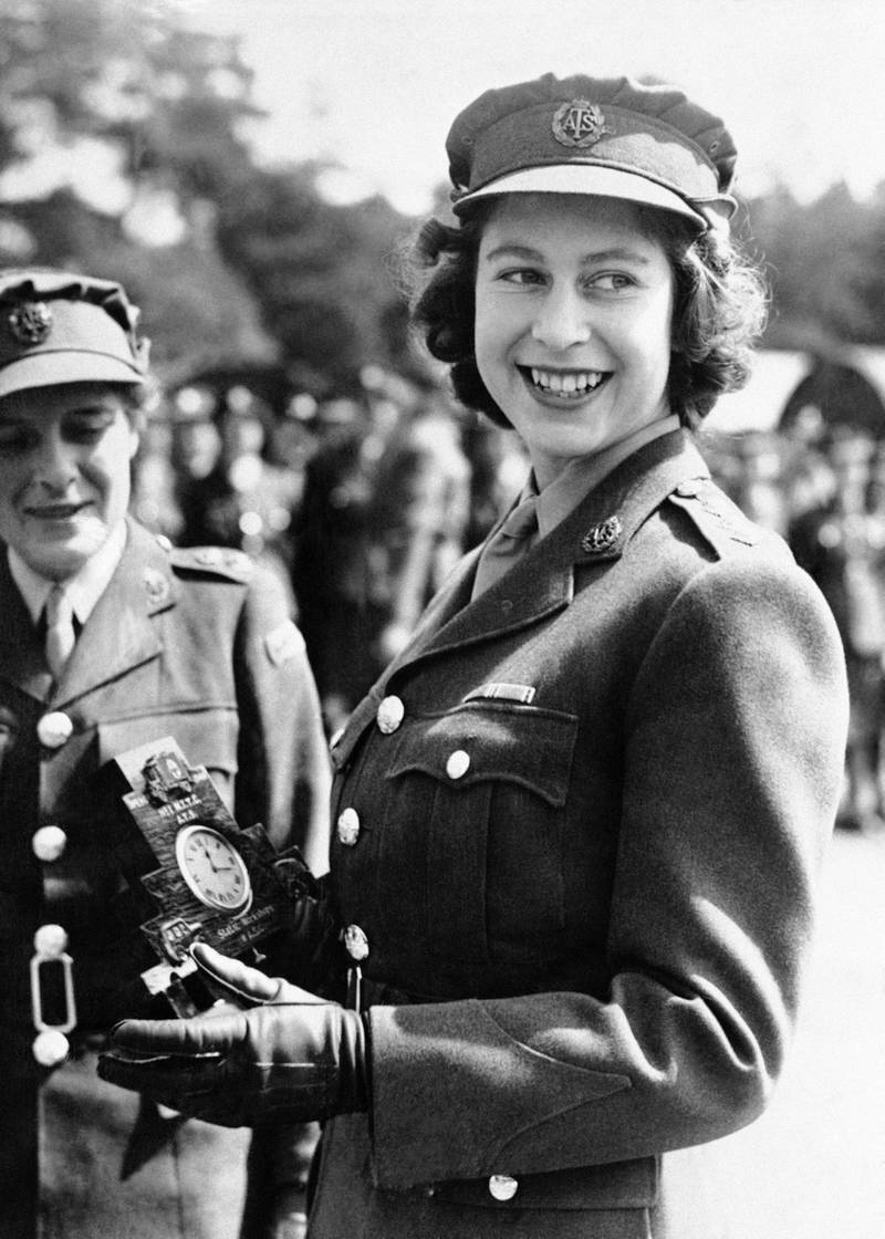 Britain's Princess Elizabeth, a Junior Commander in the Auxiliary Territorial Service, receives a clock presented to her by her old associates at the camp where she received her early training, during a ceremony at the No. 1 M.T. Training Center, in Camberley, England, Aug. 3, 1945.